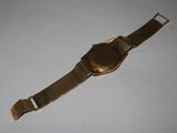 an image of a gold wrist watch on a white surface