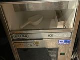 an ice cream machine with a spoon and spoon in it