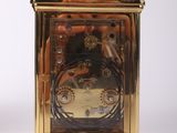 a gold clock that is sitting on a white surface