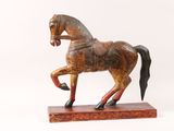 wooden statue of a horse with a saddle on a white background