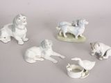 five figurines of animals and a cup on a table