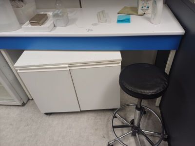 un comptoir blanc avec un plan de travail bleu et un tabouret noir