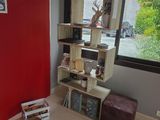 un mur rouge dans un coin d'une pièce où se trouve une bibliothèque