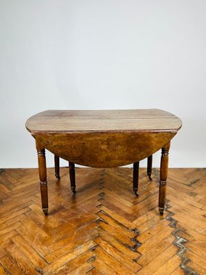 une petite table avec un plateau en bois posée sur un plancher en bois