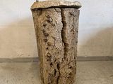 a vase made out of a tree stump on the floor