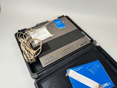 un ordinateur portable posé sur une valise en plastique
