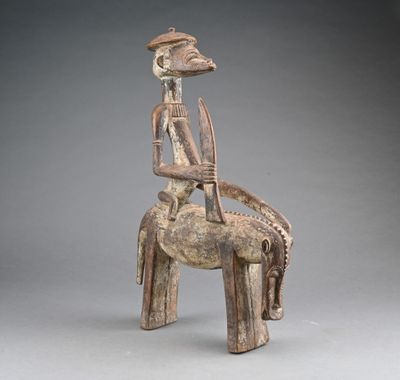 une statue en bois représentant un homme assis sur un cheval
