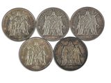 six pièces d'argent de tailles et de formes différentes sur un fond blanc