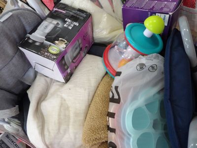 a pile of baby items in a basket with a baby bottle