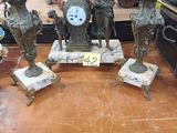 une table sur laquelle se trouvent plusieurs statues et une horloge
