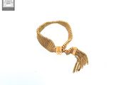 an image of a gold bracelet with a tassel hanging from it