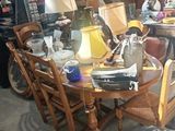 une table avec des chaises et une lampe posée dessus, dans une pièce