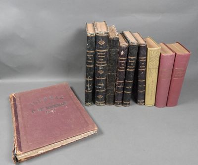 several old books are lined up in a row on a gray surface