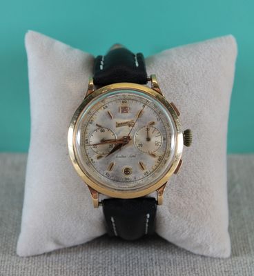 an image of a gold wrist watch on a pillow on a blue background