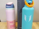 two water bottles sitting on a table next to each other