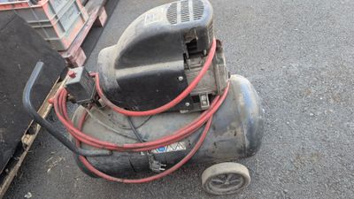 un petit compresseur d'air posé par terre