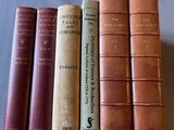 several old books are lined up in a row on a table