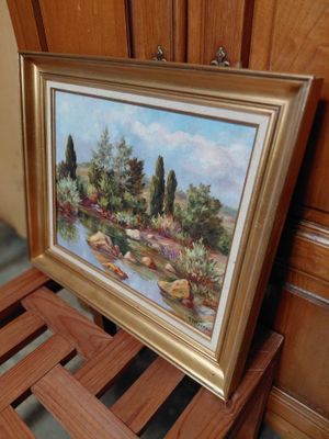 a picture of a painting hanging on a wall next to a wooden chair