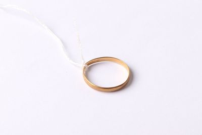 a close up of a gold wedding ring on a white background