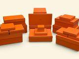 Plusieurs boîtes orange sont empilées les unes sur les autres sur une surface blanche