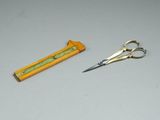 a pair of scissors next to a ruler on a table