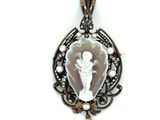 a close up of a pendant on a white background with pearls