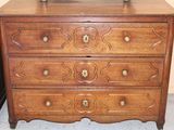 a wooden chest of drawers with a clock on top of it