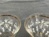 pair of glass cups with gold rims on a black surface