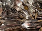 many spoons, forks and spoons in a metal container