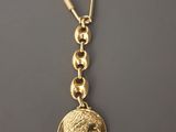 un porte-clés plaqué or orné d'une pièce de monnaie