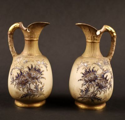 pair of antique vases with floral designs on them against a black background