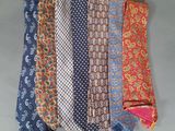 six different colored neck ties laid out on a gray surface