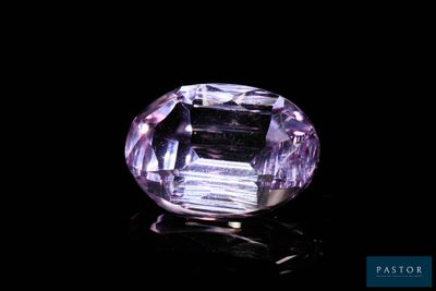 a close up of a purple diamond on a black surface