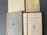 Plusieurs vieux livres sont posés sur une table, à côté d'une paire de chaussures