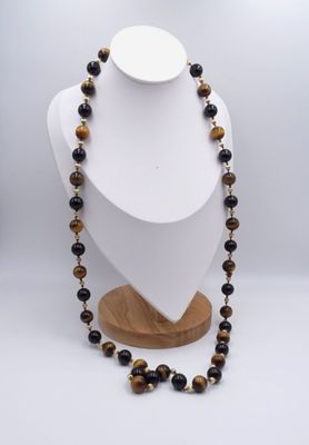 un collier composé de perles en œil-de-tigre montées sur un support en bois