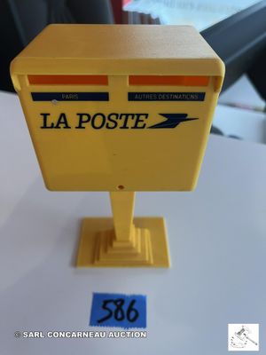 une boîte aux lettres jaune posée sur une table blanche