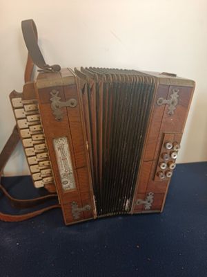an old wooden accordion sitting on a blue surface