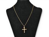 a gold cross necklace on a mannequin mannequin