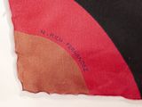 a close up of a piece of fabric with a red, black, and brown design