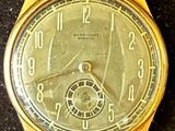 an image of a gold wrist watch with roman numerals on the face