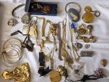 beaucoup de bijoux en or et en argent posés sur un lit