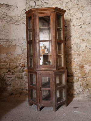 un grand meuble en bois avec des portes en verre dans une pièce