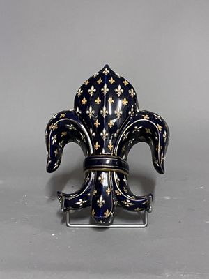 une image représentant une figurine en forme de fleur de lys bleue et dorée