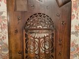 an old wooden clock with a bird on it sitting on top of a table
