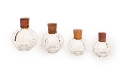 trois petites bouteilles en verre avec des couvercles en bois, posées sur une surface blanche
