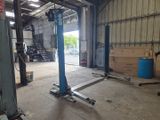 une photo d'un garage avec un pont élévateur au milieu