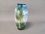 a vase with a painting on it sitting on a table