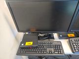 deux écrans d'ordinateur et un clavier posés sur un bureau