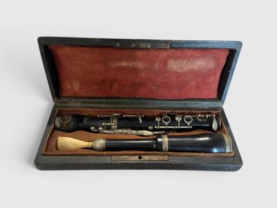 une clarinette noire et argentée dans un étui en bois