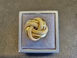 un gros plan d'une bague en or dans un écrin posé sur une table